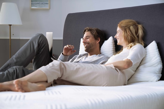 Couple smiling couch on their bed